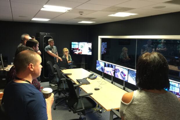 Group of people looking at testing results on PC screens in the lab