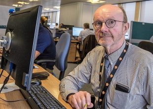 Dr Gareth Rees sitting in the office in front of a computer