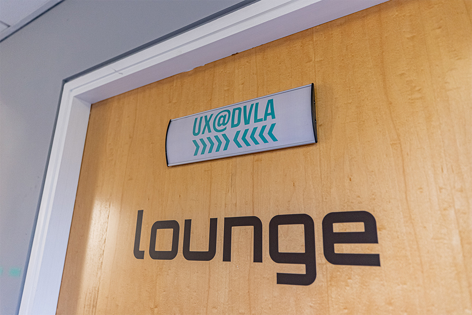 Door with a UX@DVLA sign at the top of it, and a lounge sign underneath.