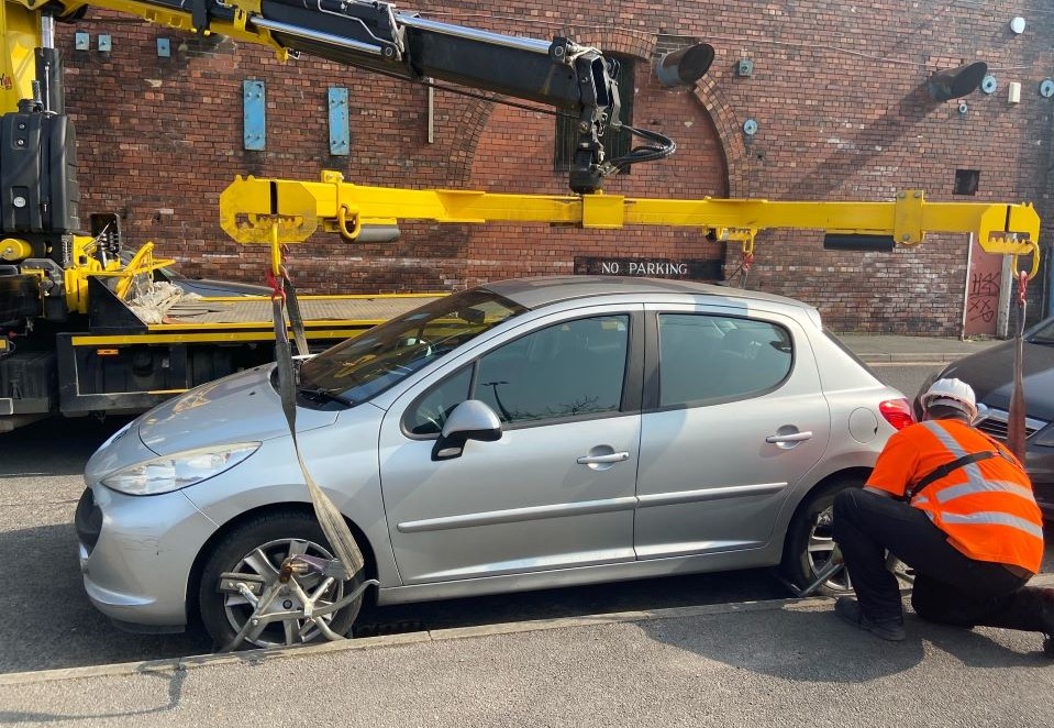 A vehicle being clamped and lifted.
